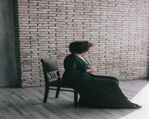 Woman stretching arms while sitting on a chair at home
